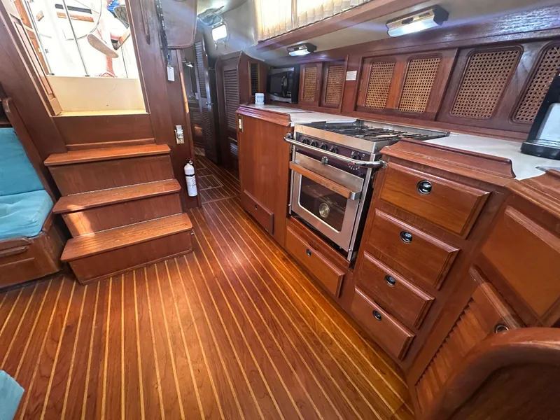 Slide: The Image of Interior of 1981 Islander Freeport Ketch with wooden cabinetry and stove in the galley. - 44