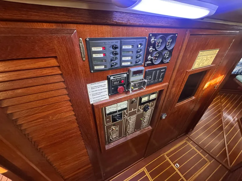 Slide: The Image of Control panel on 1981 Islander Freeport Ketch, featuring wood finish and electrical gauges. - 47