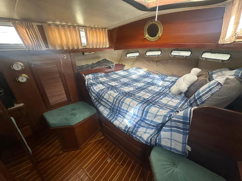 Slide: The Image of Cozy cabin interior of 1981 Islander Freeport Ketch with plaid bedding and wooden accents. - 49