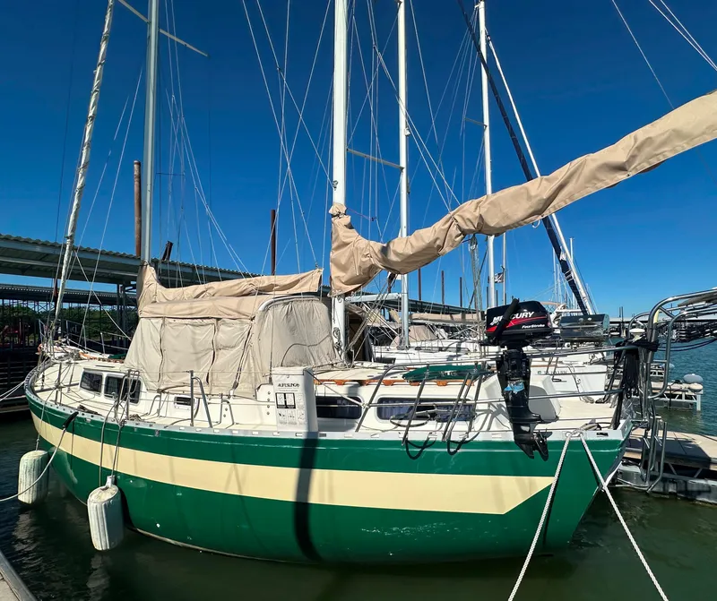 Slide: The Image of 1981 Islander Freeport Ketch sailboat docked, featuring green and cream hull, under clear blue sky. - 5