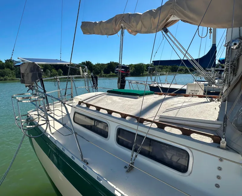Slide: The Image of 1981 Islander Freeport Ketch sailboat docked on a sunny day, featuring a spacious deck. - 9