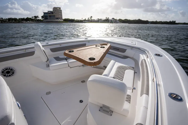 Slide: The Image of 2025 Caymas 291 boat interior with seating and table on calm water. - 2