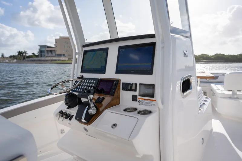 Slide: The Image of 2025 Caymas 291 boat dashboard with dual screens and steering wheel on open water. - 3
