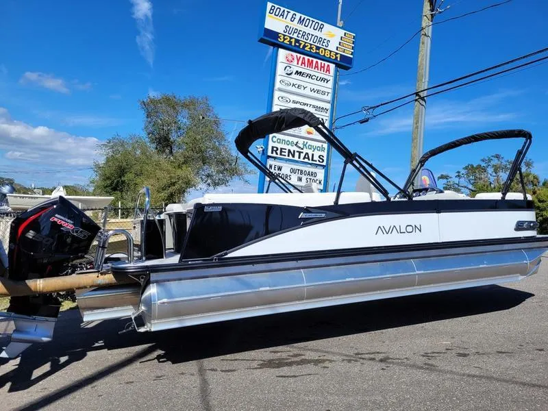 Slide: The Image of 2025 Avalon 2585 Catalina Quad Lounger pontoon boat at dealership, sunny day. - 2
