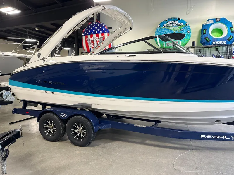 The Image of 2025 Regal LS6 boat on trailer in showroom, featuring sleek design and modern amenities. - 0