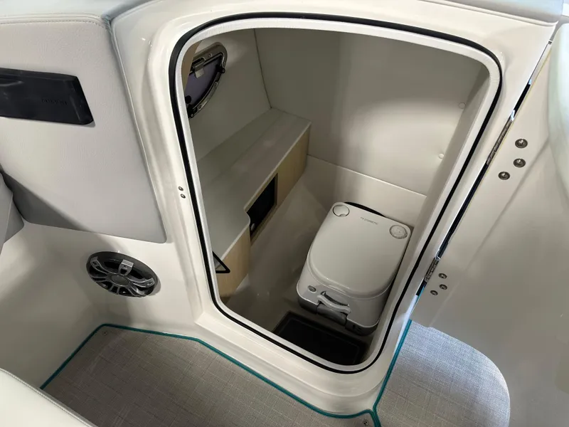 Slide: The Image of 2025 Regal LS6 boat interior with compact marine toilet and storage space. - 13