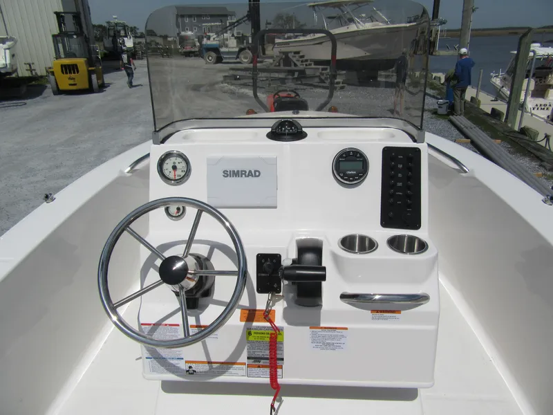Slide: The Image of 2025 Robalo R160 Center Console boat dashboard with steering wheel and controls. - 2