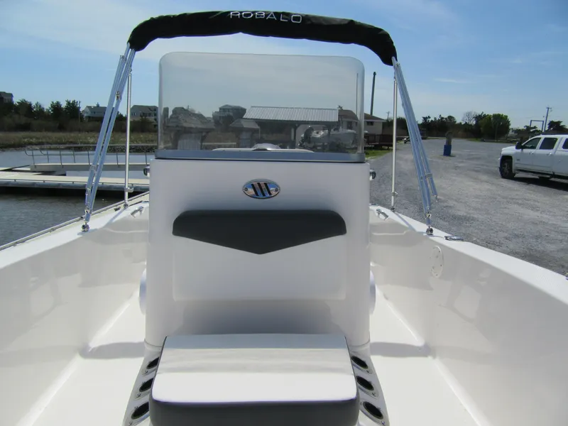 Slide: The Image of 2025 Robalo R160 Center Console boat with sleek design, docked outdoors. - 5