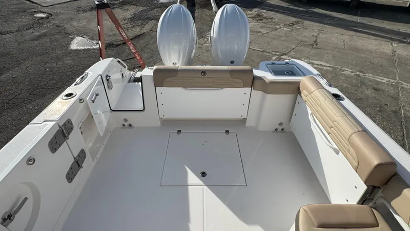 Slide: The Image of 2025 Edgewater 262CX boat interior with beige seating and dual outboard motors. - 11