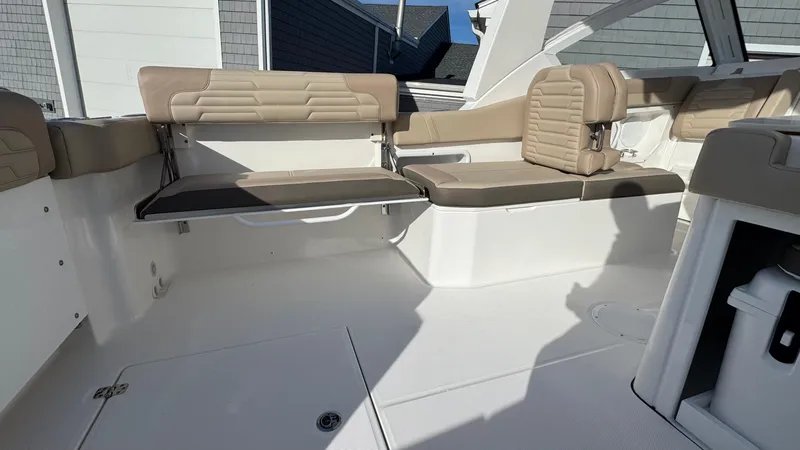 Slide: The Image of Interior seating of 2025 Edgewater 262CX boat with beige cushions. - 16