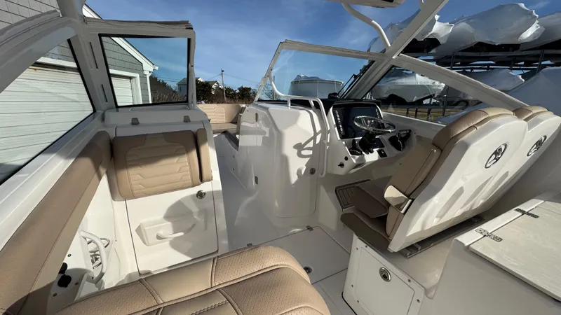 Slide: The Image of 2025 Edgewater 262CX boat interior with beige seating and modern dashboard. - 19