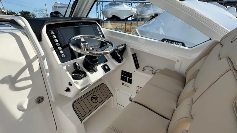 Slide: The Image of 2025 Edgewater 262CX boat interior with modern dashboard and beige seating. - 24