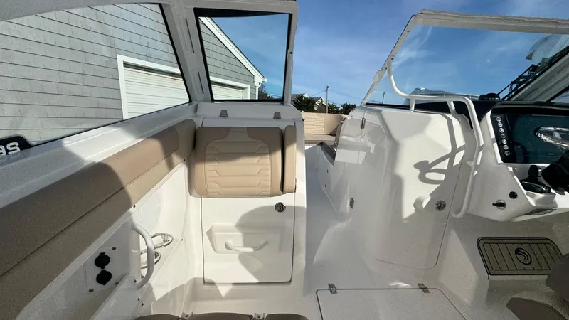Slide: The Image of 2025 Edgewater 262CX boat interior with beige seating and modern dashboard. - 26
