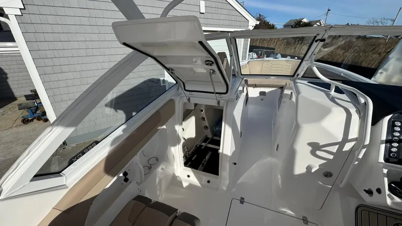 Slide: The Image of 2025 Edgewater 262CX boat interior with open storage compartment, showcasing sleek design and seating. - 27
