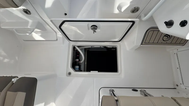 Slide: The Image of 2025 Edgewater 262CX boat interior with open storage compartment and seating. - 28