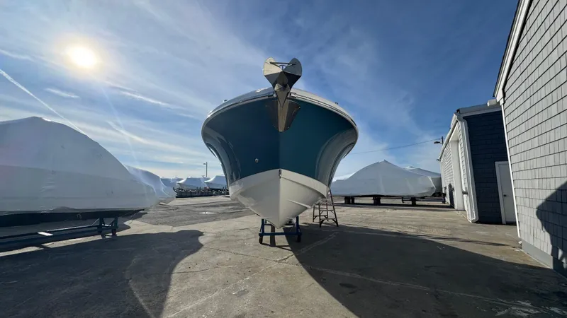 Slide: The Image of 2025 Edgewater 262CX boat in a sunny marina, surrounded by covered vessels. - 4