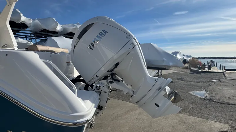 Slide: The Image of 2025 Edgewater 262CX boat with Yamaha outboard motor, docked under clear blue sky. - 6