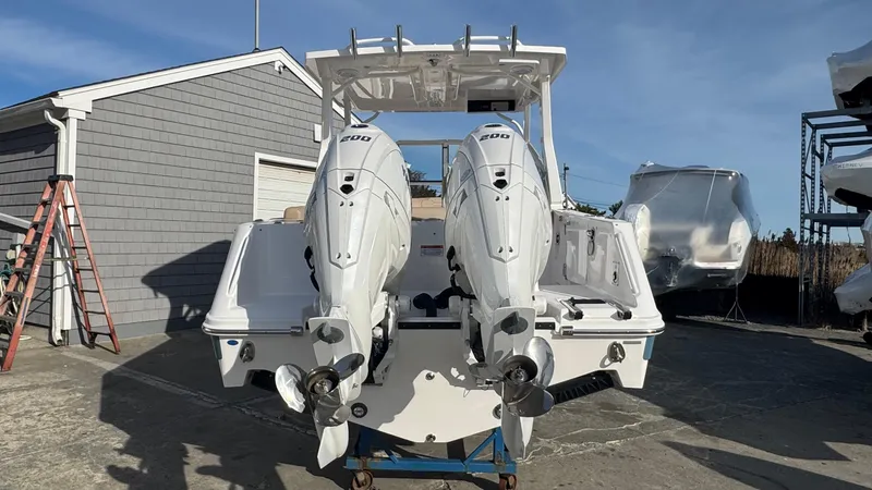 Slide: The Image of 2025 Edgewater 262CX boat with dual outboard engines, parked outdoors. - 7