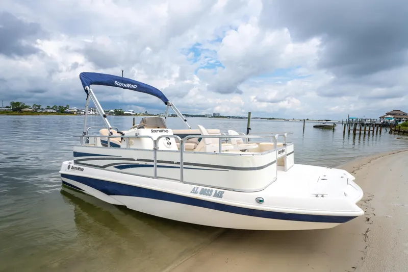 The Image of 2008 Bennington 201FS Southwind boat docked on a sandy shore under cloudy skies. - 0