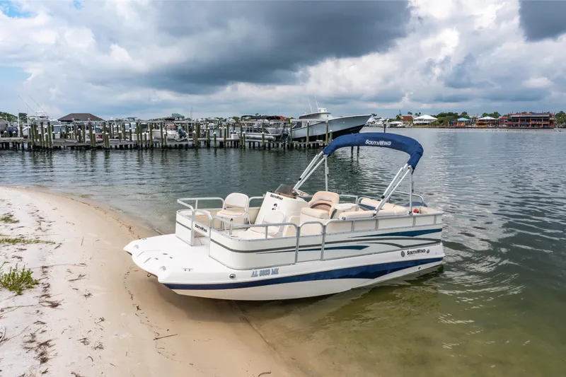 Slide: The Image of 2008 Bennington 201FS Southwind boat beached on sandy shore under cloudy sky. - 10