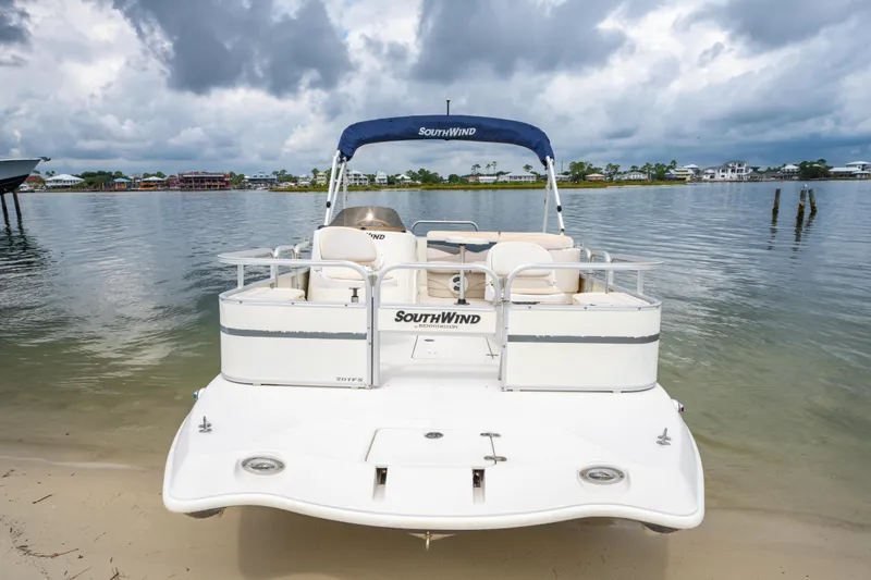 Slide: The Image of 2008 Bennington 201FS Southwind boat docked on a sandy shore under cloudy skies. - 12