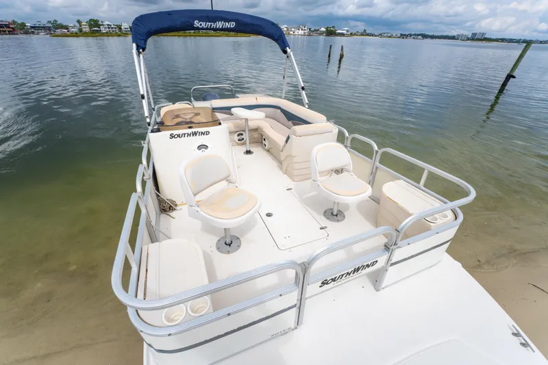 Slide: The Image of 2008 Bennington 201FS Southwind boat with seating, docked by a calm shoreline. - 14