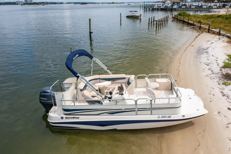 Slide: The Image of 2008 Bennington 201FS Southwind boat docked on a sandy shoreline. - 2