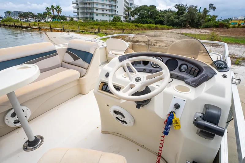 Slide: The Image of 2008 Bennington 201FS Southwind boat interior with steering wheel and seating, near waterfront. - 22