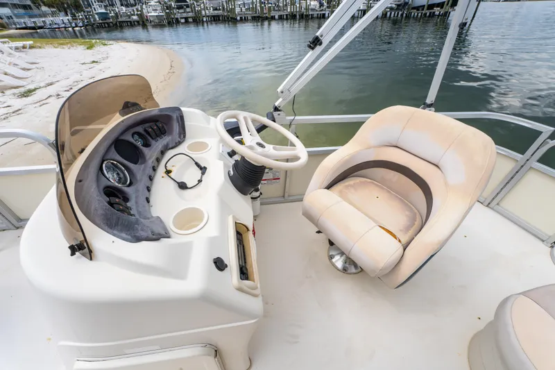 Slide: The Image of 2008 Bennington 201FS Southwind boat interior with steering console and captain's chair by the water. - 24