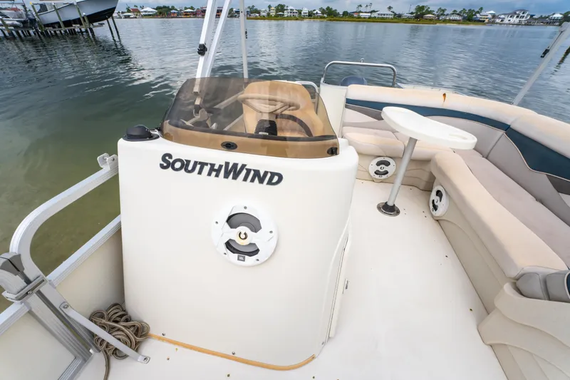 Slide: The Image of 2008 Bennington 201FS Southwind boat interior with seating and table, docked by the water. - 25