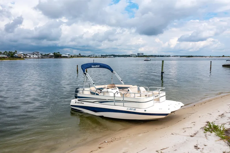 Slide: The Image of 2008 Bennington 201FS Southwind boat on sandy shore with cloudy sky backdrop. - 26
