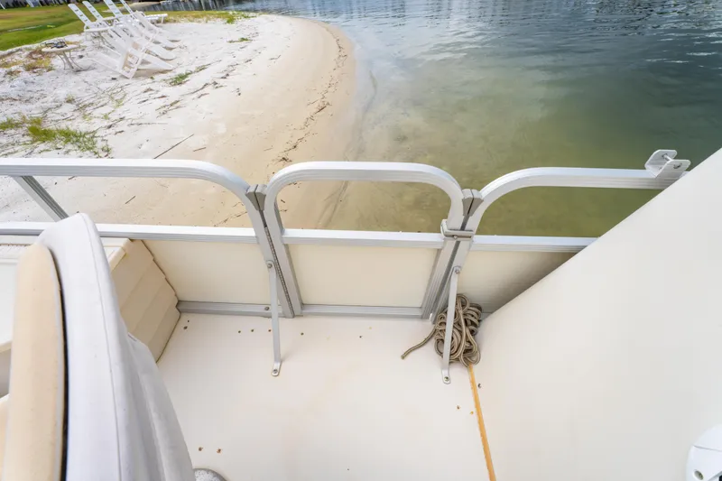 Slide: The Image of 2008 Bennington 201FS Southwind boat docked on sandy beach with chairs nearby. - 28