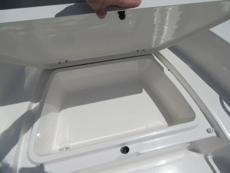 Slide: The Image of 2025 Robalo R160 Center Console storage compartment open, showcasing interior space. - 5