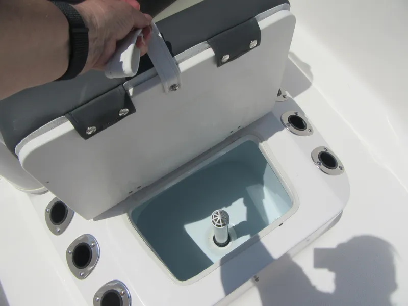 Slide: The Image of 2025 Robalo R160 Center Console boat seat storage compartment with rod holders. - 7
