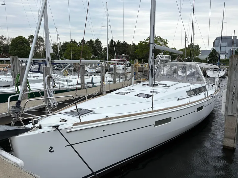 The Image of 2018 Beneteau Oceanis 45 sailboat docked at marina, surrounded by other boats. - 0
