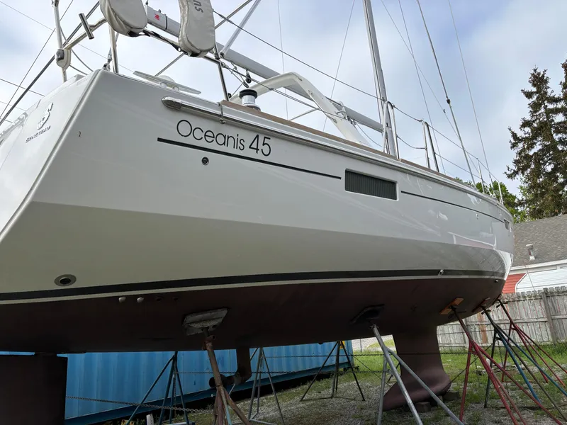 Slide: The Image of 2018 Beneteau Oceanis 45 sailboat on stands, side view, in a yard setting. - 10