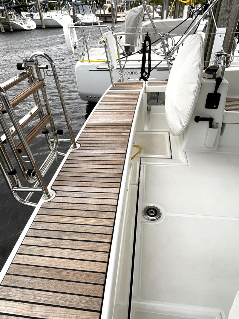 Slide: The Image of Beneteau Oceanis 45 yacht deck, 2018 model, featuring teak wood and stainless steel fittings. - 44
