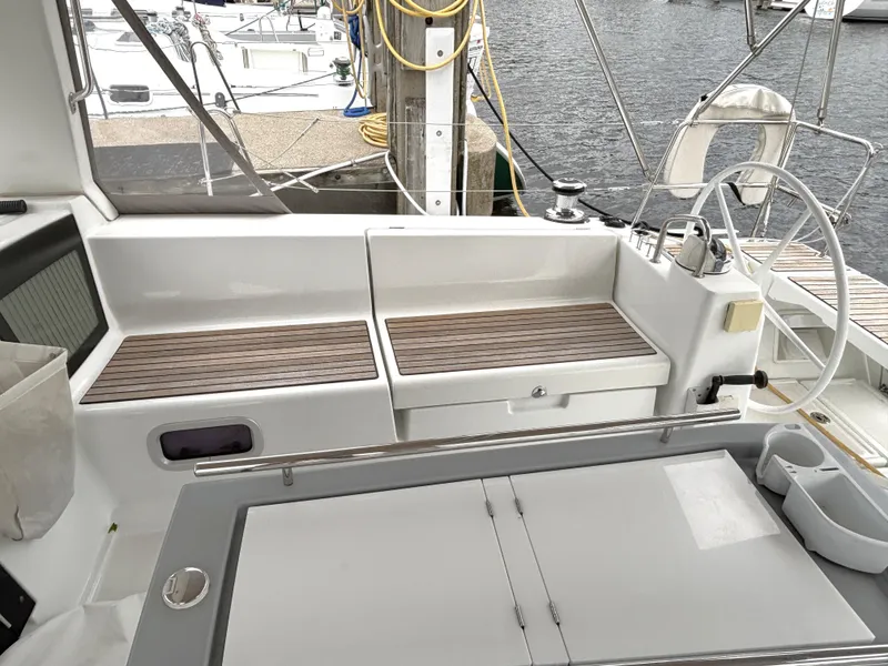 Slide: The Image of Cockpit of 2018 Beneteau Oceanis 45 sailboat with wooden seating and steering wheel. - 46