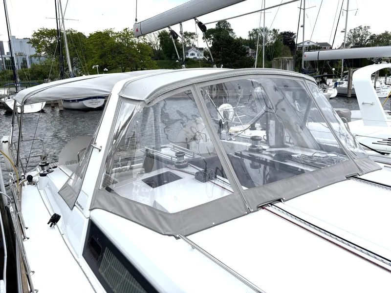Slide: The Image of 2018 Beneteau Oceanis 45 sailboat with cockpit enclosure, docked in a marina. - 7