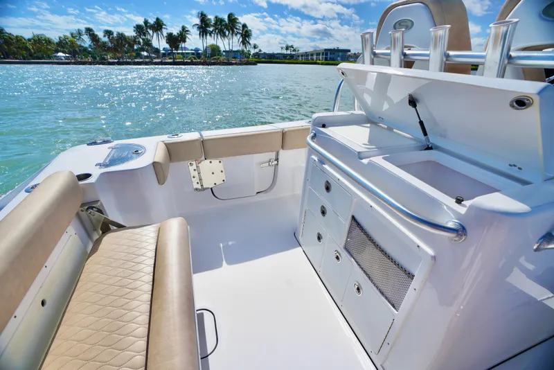 Slide: The Image of 2019 Sportsman Open 282 Center Console boat interior with seating and storage, on a sunny day. - 12
