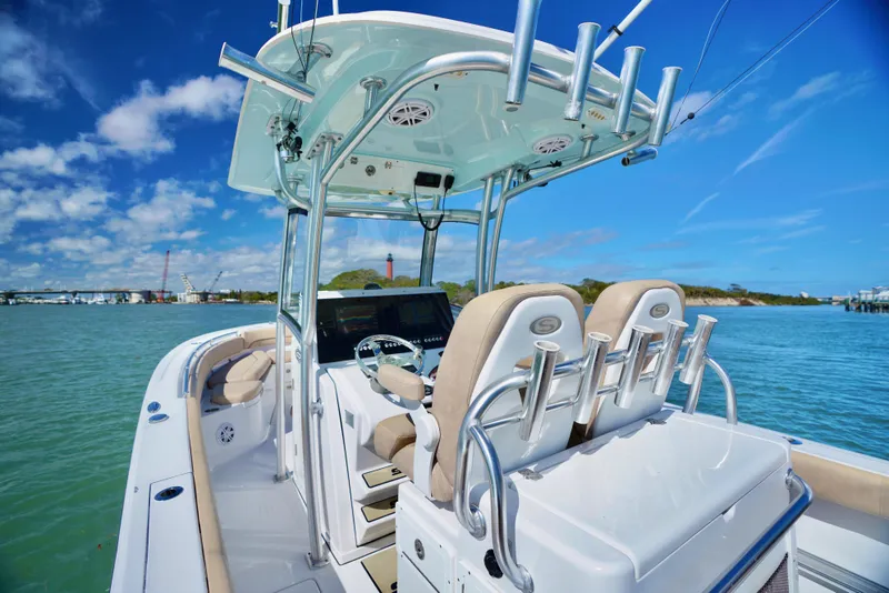 Slide: The Image of 2019 Sportsman Open 282 Center Console boat on water, featuring dual seats and fishing rod holders. - 3