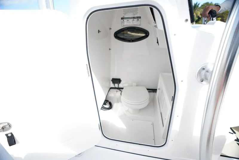 Slide: The Image of 2019 Sportsman Open 282 Center Console boat interior with compact marine toilet. - 9