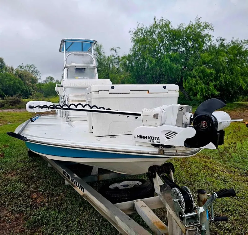 Slide: The Image of 2009 NewWater 22 boat with Minn Kota motor on trailer, surrounded by greenery. - 2
