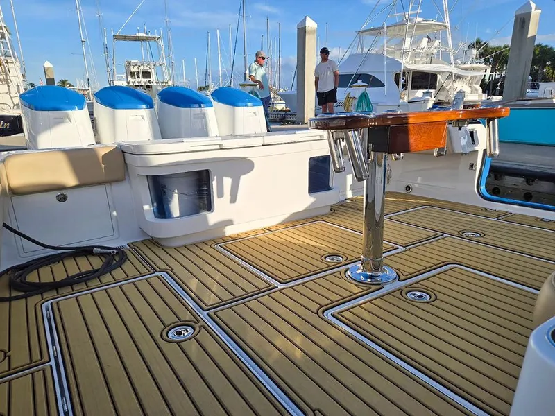 Slide: The Image of 2023 HCB Suenos boat deck with teak flooring and seating, docked at marina. - 11