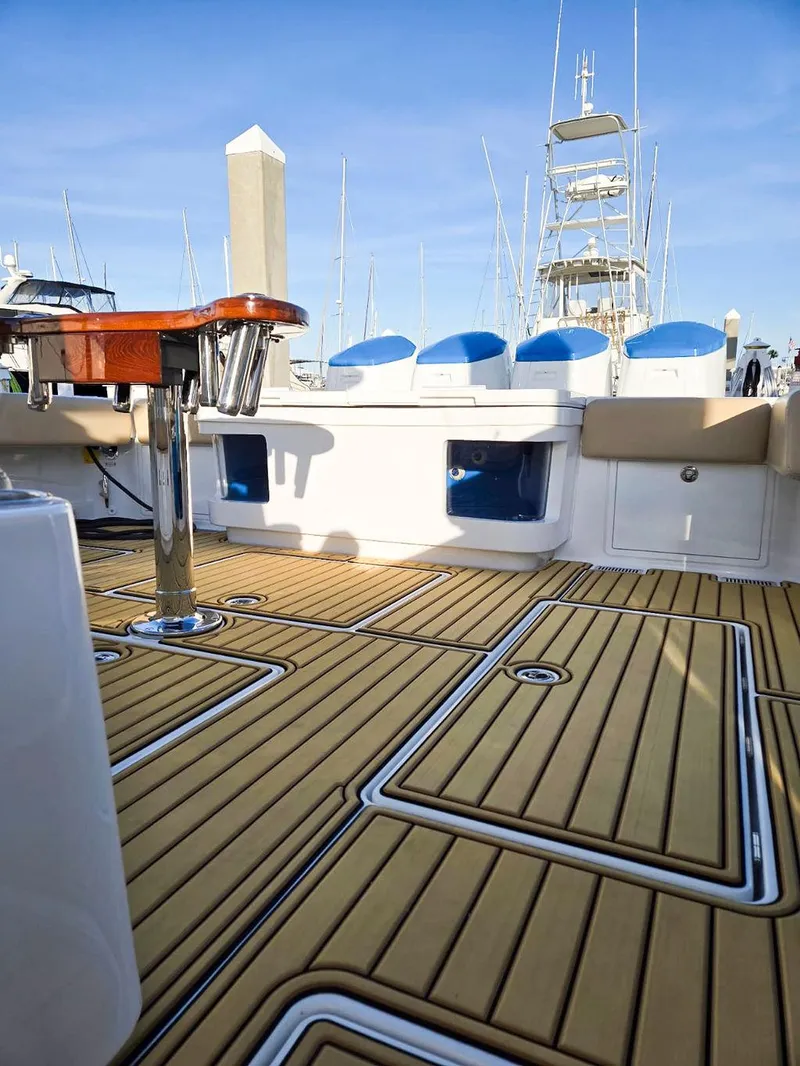 Slide: The Image of 2023 HCB Suenos yacht with luxurious deck and seating, docked at marina under blue sky. - 12