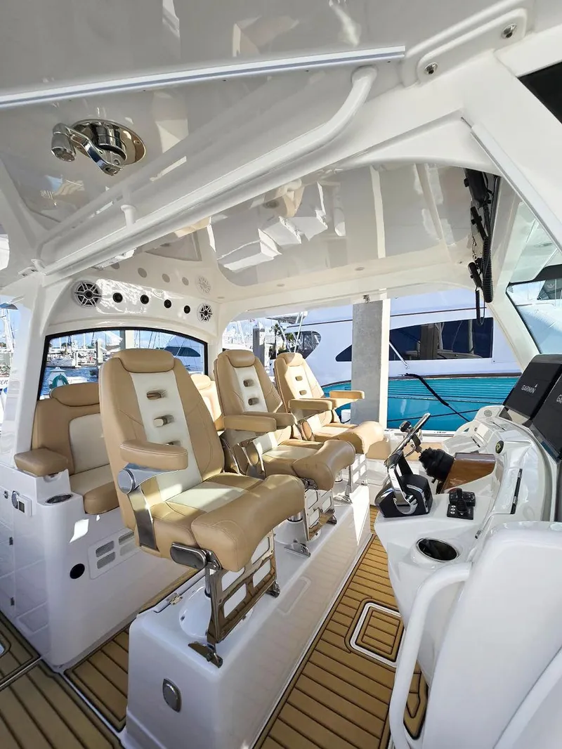 Slide: The Image of 2023 HCB Suenos boat interior with beige seats and Garmin navigation displays. - 23
