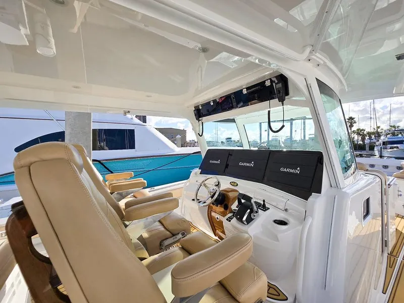 Slide: The Image of 2023 HCB Suenos boat interior with three tan seats and a modern dashboard. - 24