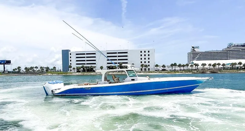 Slide: The Image of 2023 HCB Suenos boat cruising on water near modern buildings. - 3