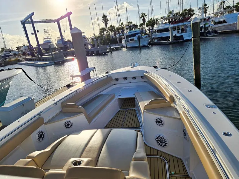 Slide: The Image of 2023 HCB Suenos boat deck with speakers, docked at marina with yachts in background. - 45