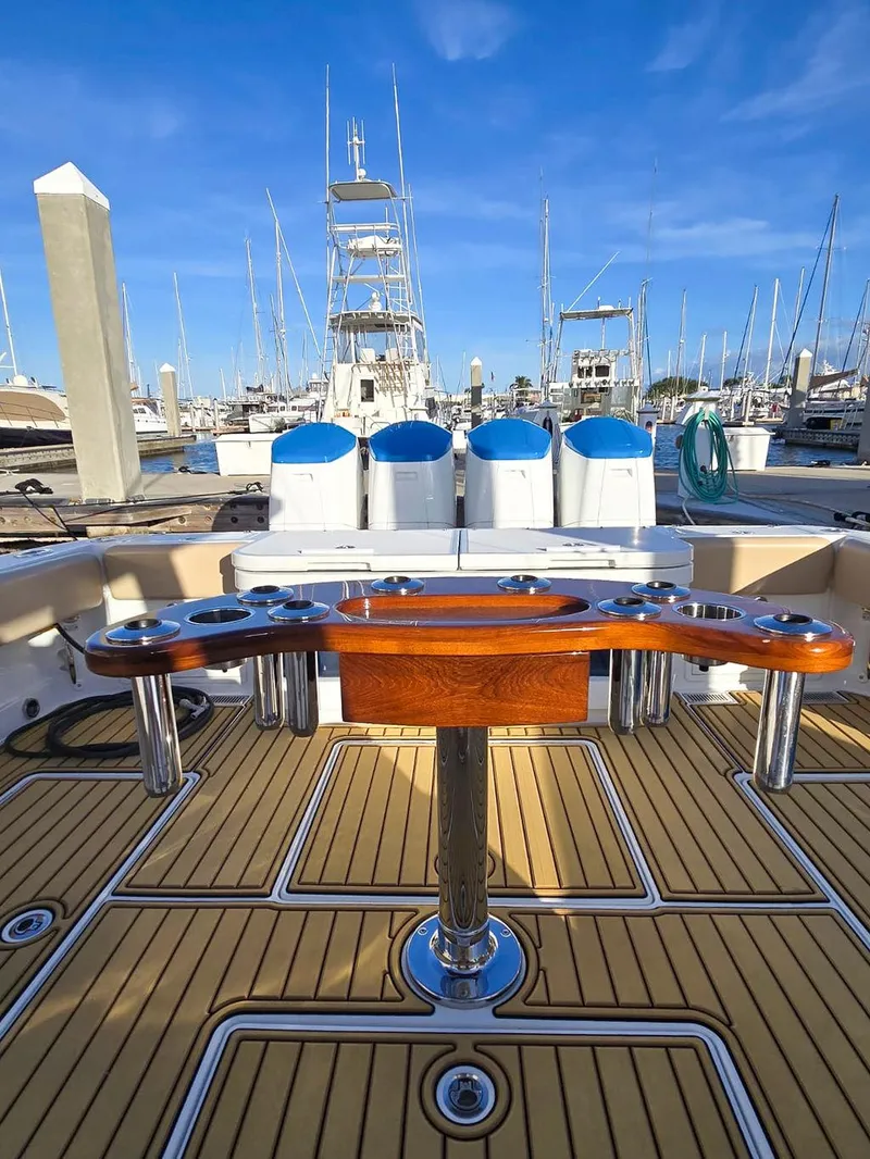 Slide: The Image of 2023 HCB Suenos boat deck with teak flooring and fishing equipment at marina. - 10